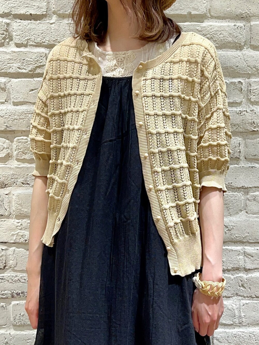 ベージュ系のTシャツ/カットソー、ベージュ系のカーディガン/ボレロ、ブラック系のワンピースを着用したレディースの秋コーディネートの2枚目の写真