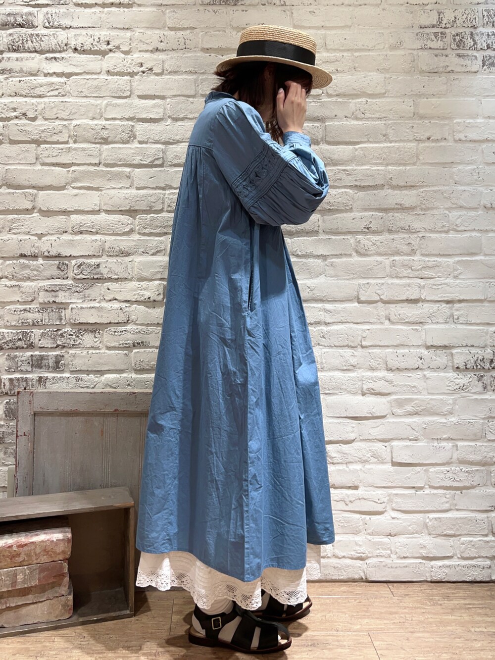 ブルー系のワンピース、ホワイト系のスカート、ブラック系のサンダルを着用したレディースの春コーディネートの3枚目の写真