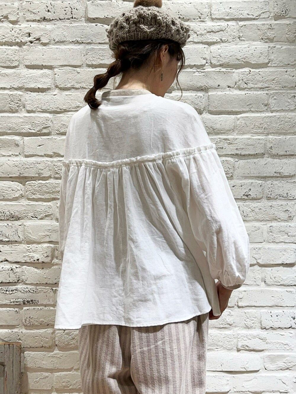 ブラウン系のカーディガン/ボレロ、ホワイト系のシャツ/ブラウス、ブラウン系のショルダーバッグを着用したレディースの冬コーディネートの5枚目の写真