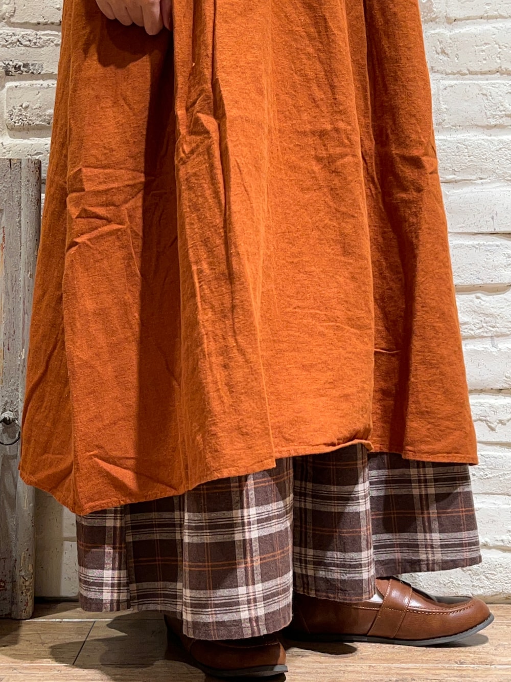 ホワイト系のTシャツ/カットソー、オレンジ系のワンピース、ブラウン系のその他パンツを着用したレディースの秋コーディネートの5枚目の写真