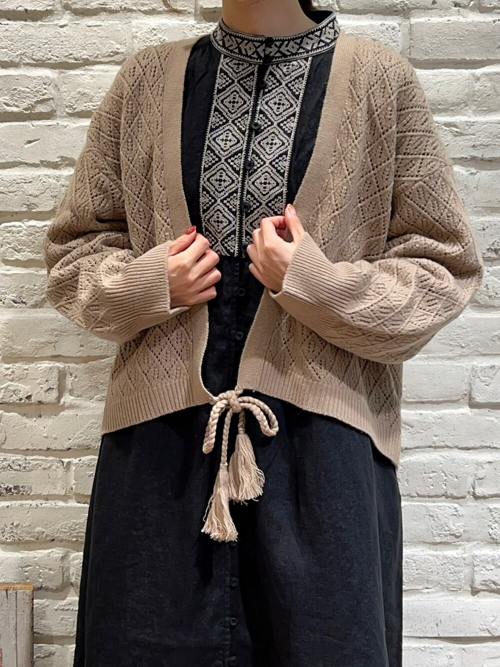 ブラック系のドレスシューズ、ベージュ系のニット/セーター、ブラック系のワンピースを着用したレディースの秋コーディネートの5枚目の写真