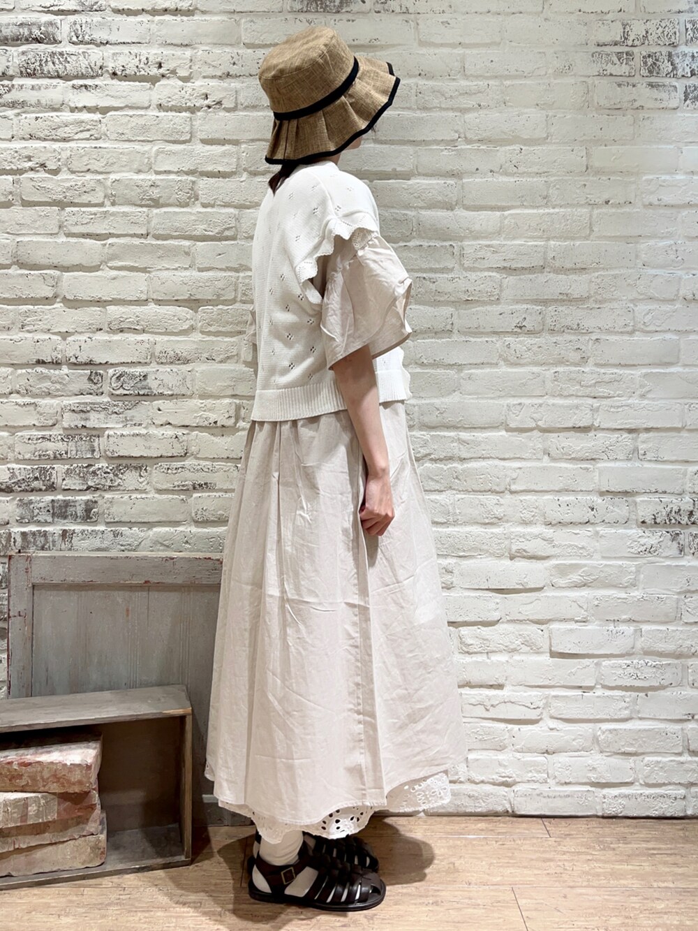 ホワイト系のタンクトップ、ホワイト系のベスト、ホワイト系のワンピースを着用したレディースの夏コーディネートの3枚目の写真