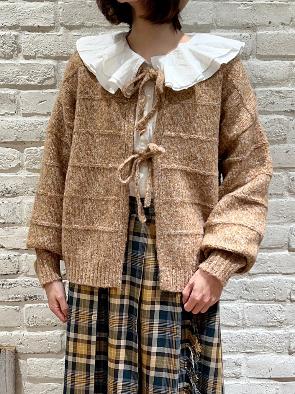 ホワイト系のシャツ/ブラウス、オレンジ系のカーディガン/ボレロ、グリーン系のスカートを着用したレディースの冬コーディネートの2枚目の写真