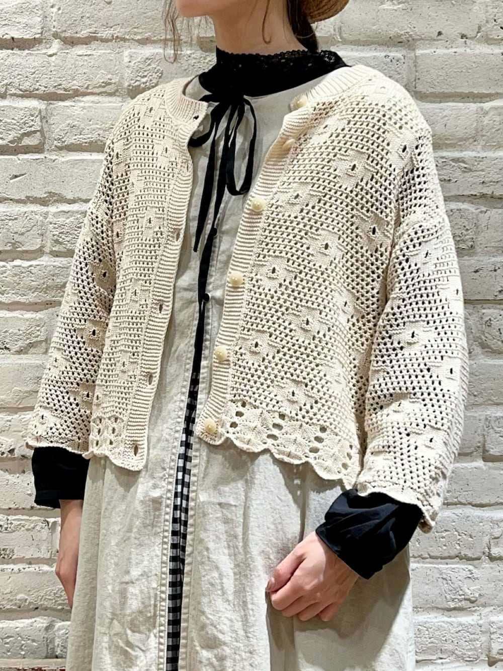 ブラック系のシャツ/ブラウス、ホワイト系のカーディガン/ボレロ、ホワイト系のワンピースを着用したレディースの春コーディネートの2枚目の写真