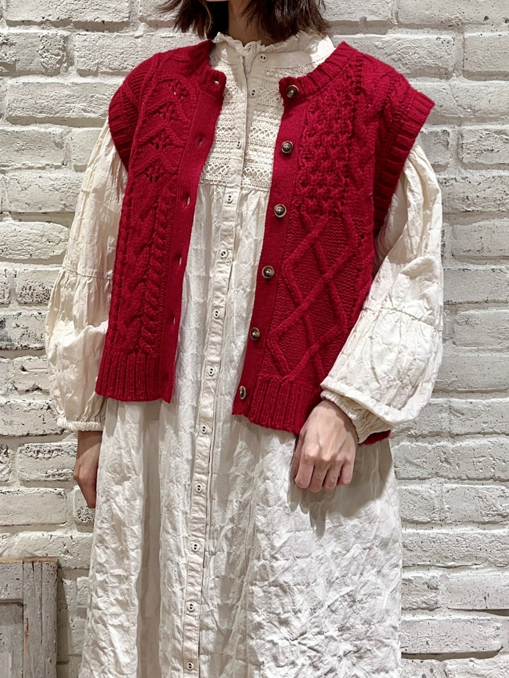 ホワイト系のシャツ/ブラウス、レッド系のベスト、ホワイト系のワンピースを着用したレディースの冬コーディネートの2枚目の写真