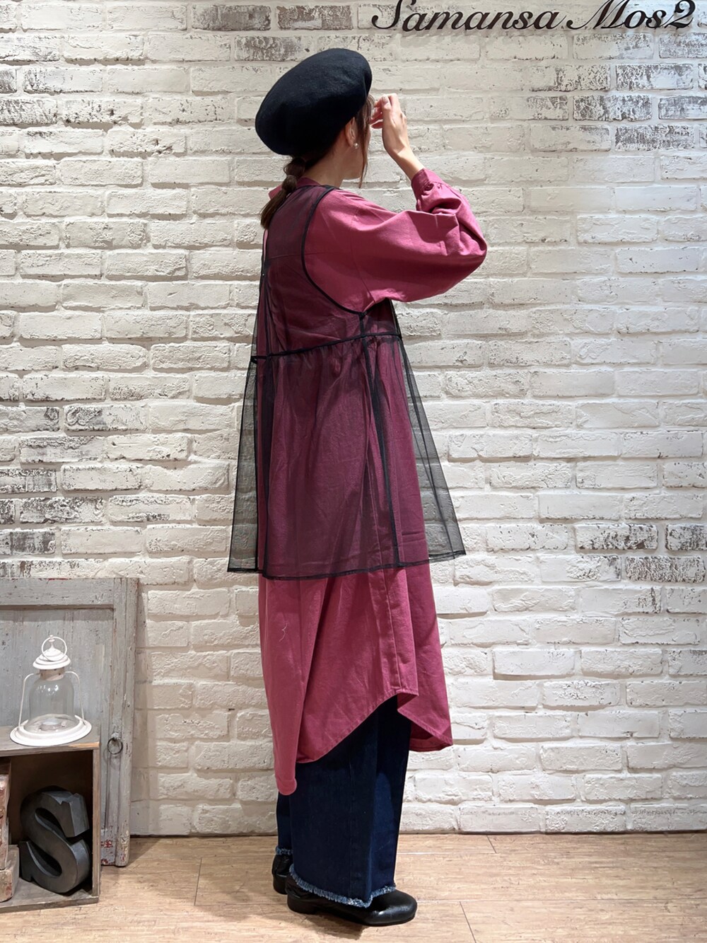 パープル系のワンピース、ブラック系のベスト、ブルー系のデニムパンツを着用したレディースの秋コーディネートの3枚目の写真