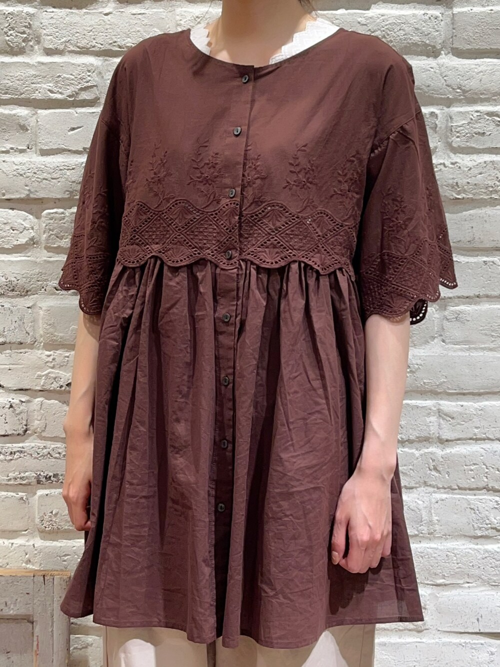 ホワイト系のTシャツ/カットソー、ブラウン系のチュニック、ベージュ系のハンドバッグを着用したレディースの夏コーディネートの2枚目の写真