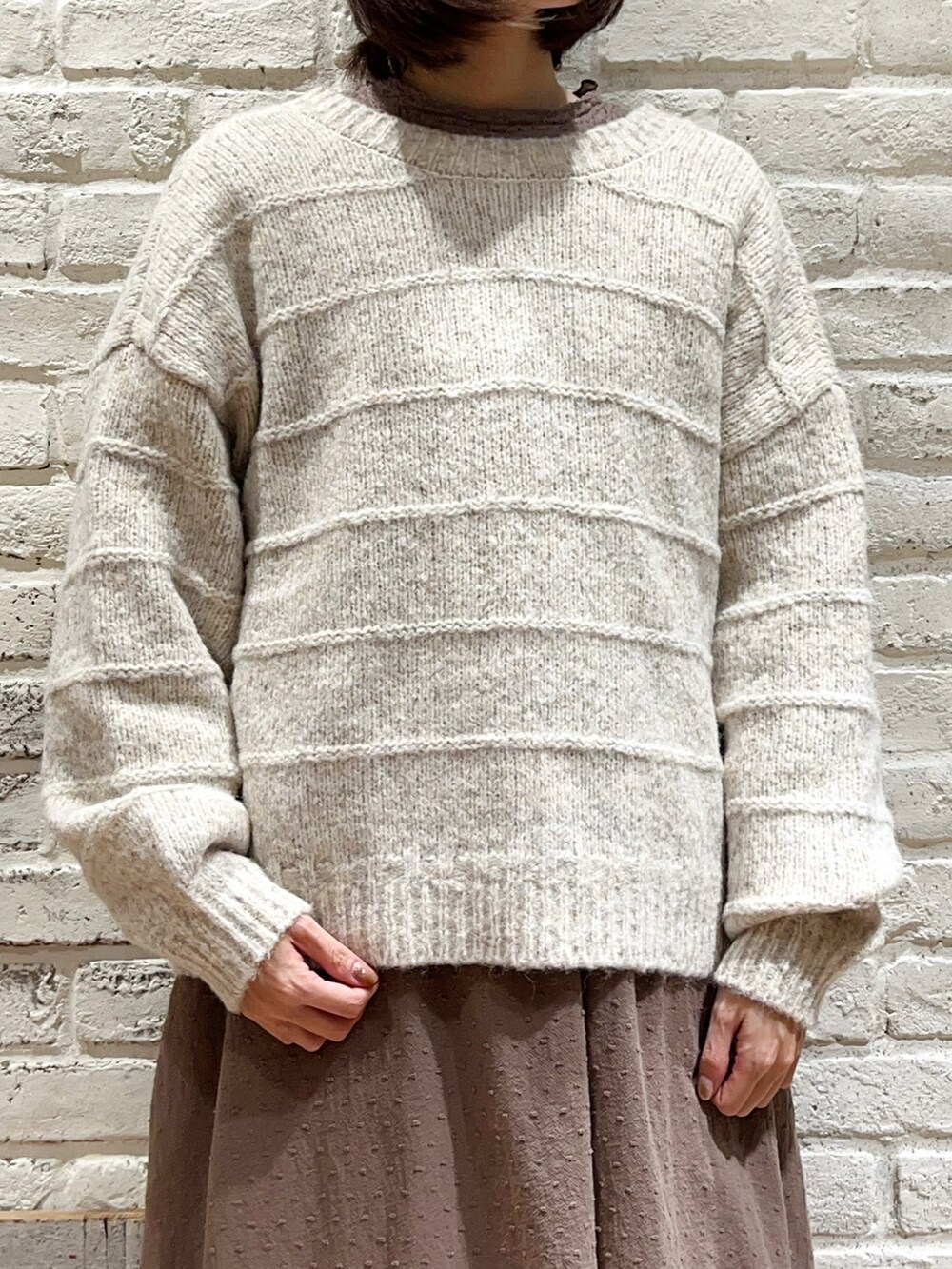 ホワイト系のカーディガン/ボレロ、ブラウン系のワンピース、ベージュ系のカーゴパンツを着用したレディースの冬コーディネートの5枚目の写真