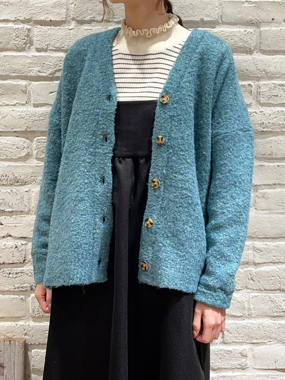 ホワイト系のニット/セーター、ブルー系のカーディガン/ボレロ、ブラック系のワンピースを着用したレディースの秋コーディネートの2枚目の写真