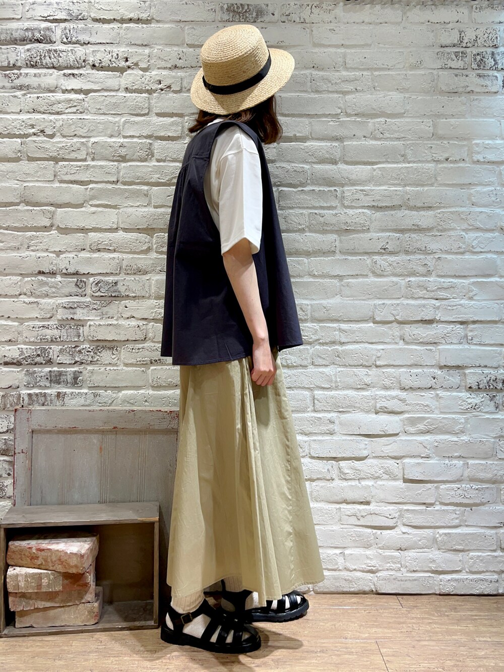 グレー系のベスト、ホワイト系のTシャツ/カットソー、グレー系のハンドバッグを着用したレディースの夏コーディネートの4枚目の写真