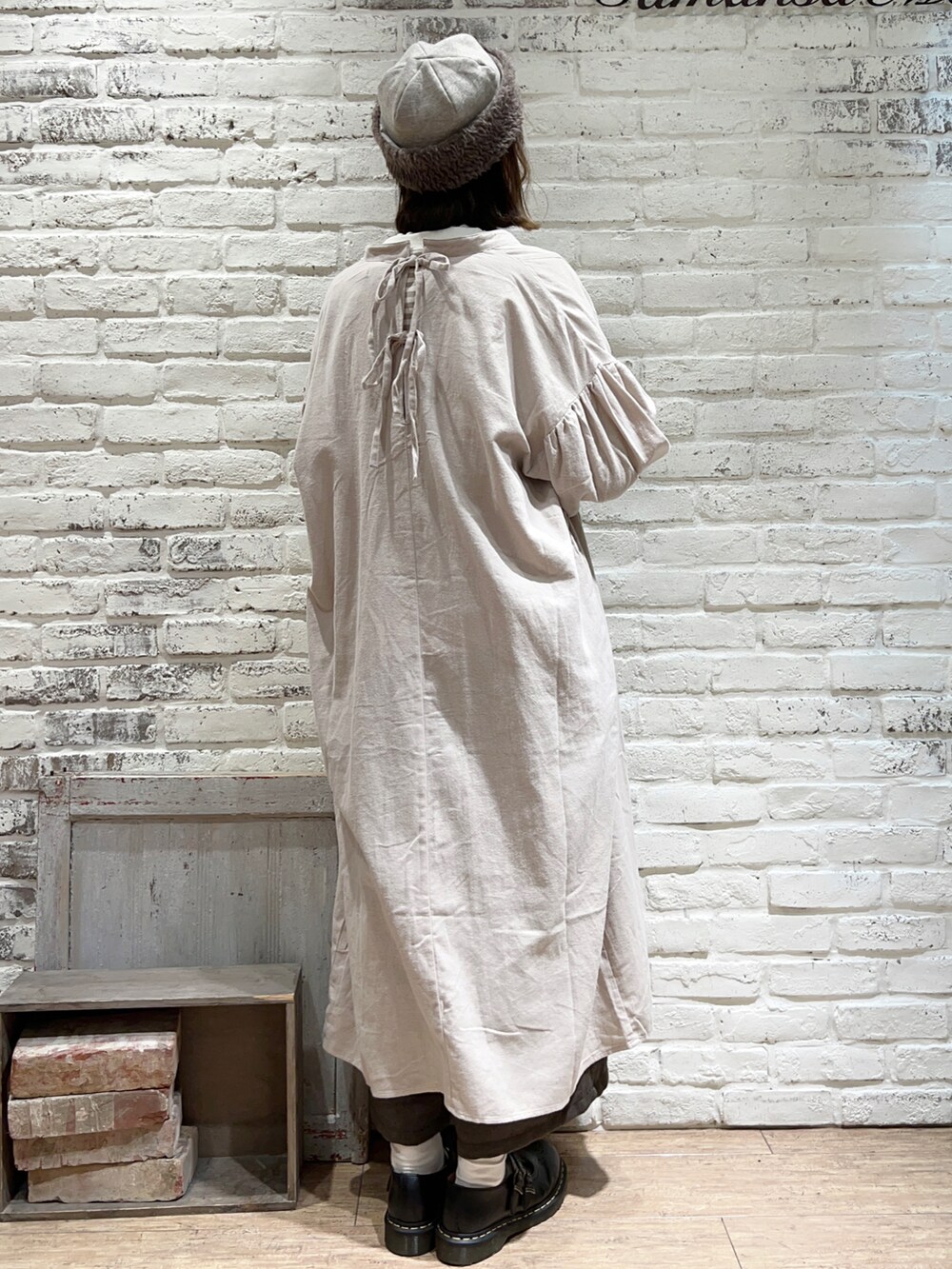 ホワイト系のTシャツ/カットソー、ホワイト系のニット/セーター、ベージュ系のワンピースを着用したレディースの冬コーディネートの4枚目の写真