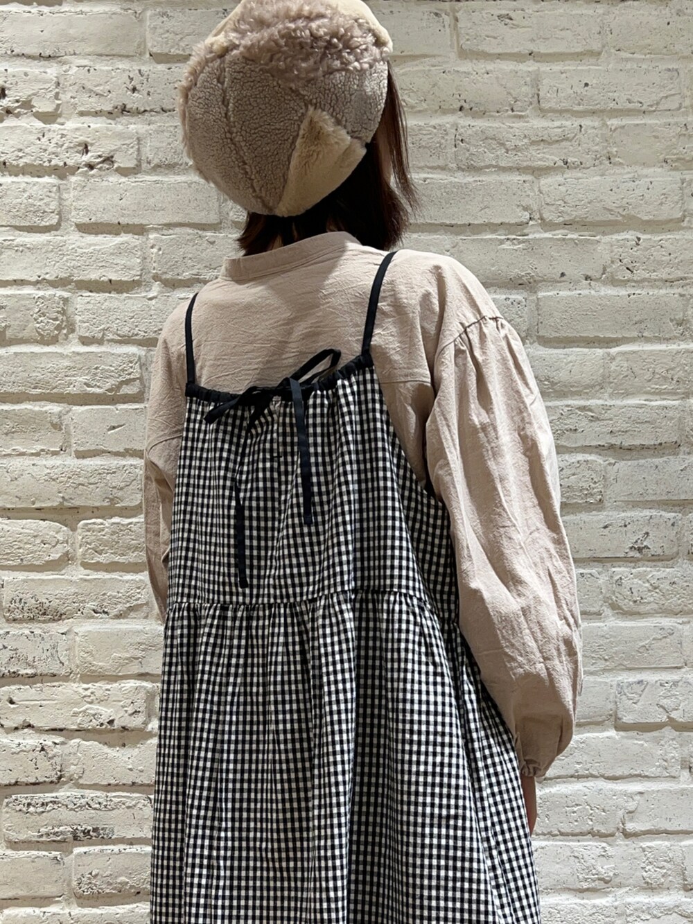 ベージュ系のチュニック、イエロー系のその他アウター、ホワイト系のブーツを着用したレディースの冬コーディネートの5枚目の写真