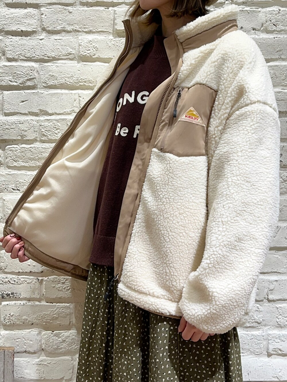 ブラック系のシャツ/ブラウス、ブラウン系のニット/セーター、ホワイト系のブルゾンを着用したレディースの秋コーディネートの3枚目の写真