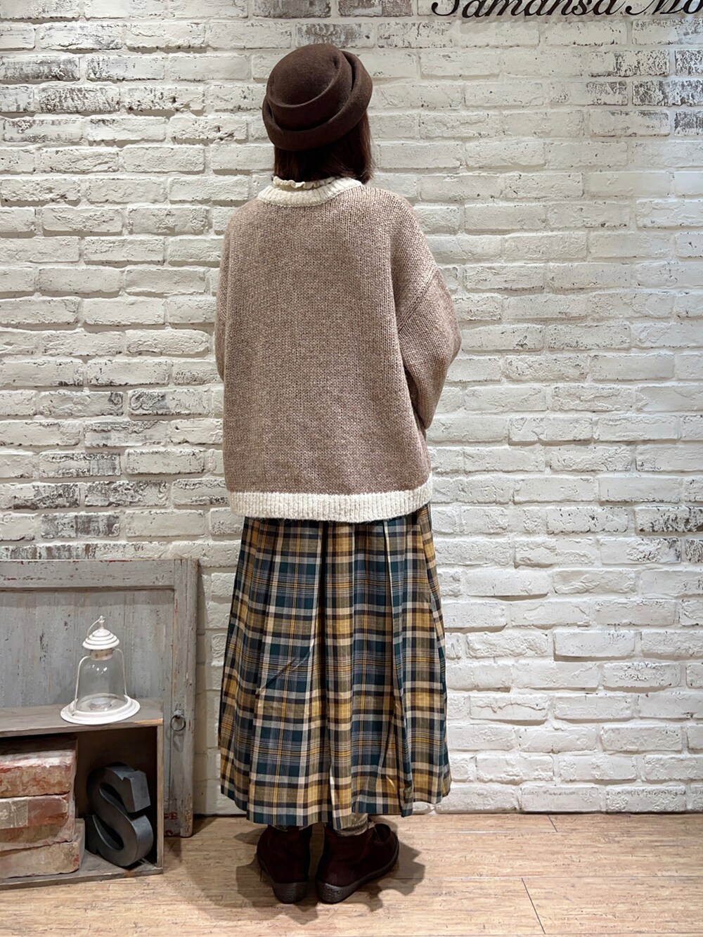 ホワイト系のニット/セーター、ベージュ系のカーディガン/ボレロ、グリーン系のスカートを着用したレディースの冬コーディネートの4枚目の写真