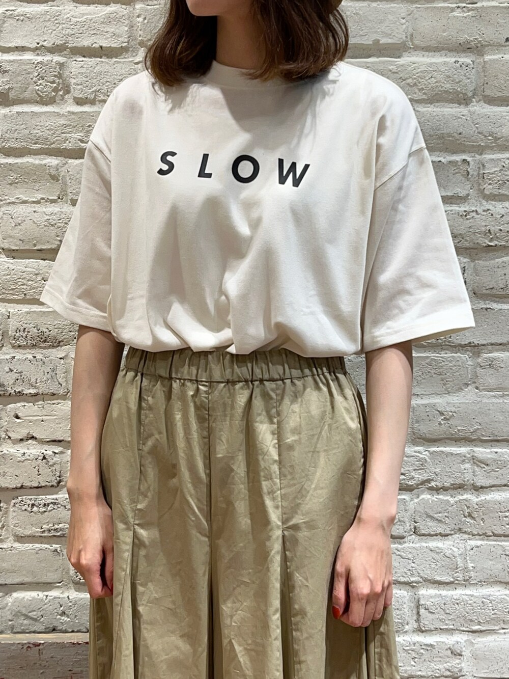 グレー系のベスト、ホワイト系のTシャツ/カットソー、グレー系のハンドバッグを着用したレディースの夏コーディネートの3枚目の写真