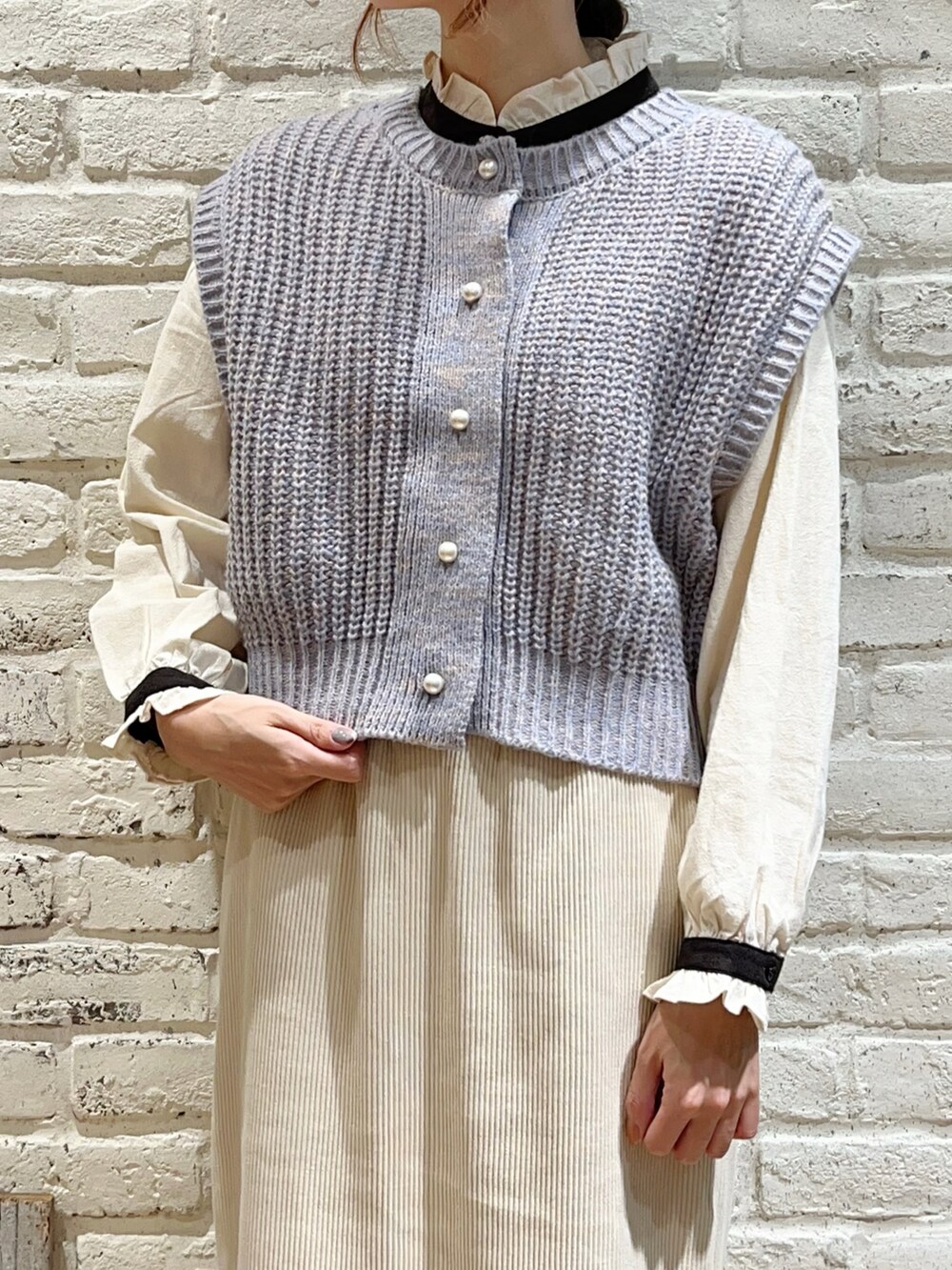 ホワイト系のシャツ/ブラウス、ブルー系のベスト、グレー系のノーカラージャケットを着用したレディースの秋コーディネートの2枚目の写真