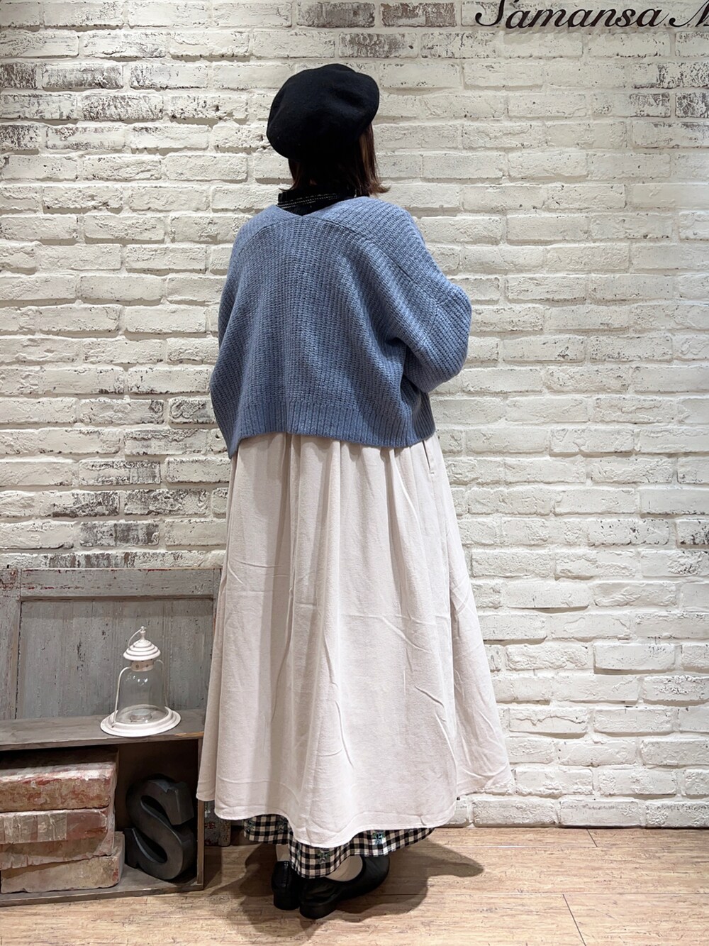 ブラック系のニット/セーター、ホワイト系のワンピース、ブルー系のカーディガン/ボレロを着用したレディースの冬コーディネートの5枚目の写真