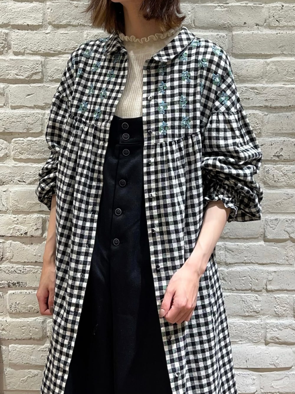 ホワイト系のニット/セーター、ブルー系のワンピース、ブラック系のサロペット/オーバーオールを着用したレディースの冬コーディネートの2枚目の写真