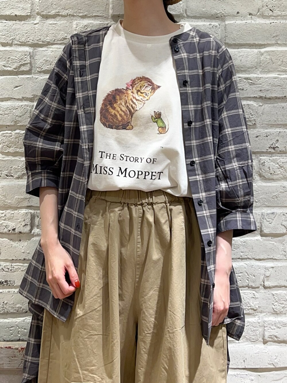 ホワイト系のTシャツ/カットソー、ブラウン系のチュニック、ブラック系のハンドバッグを着用したレディースの夏コーディネートの2枚目の写真