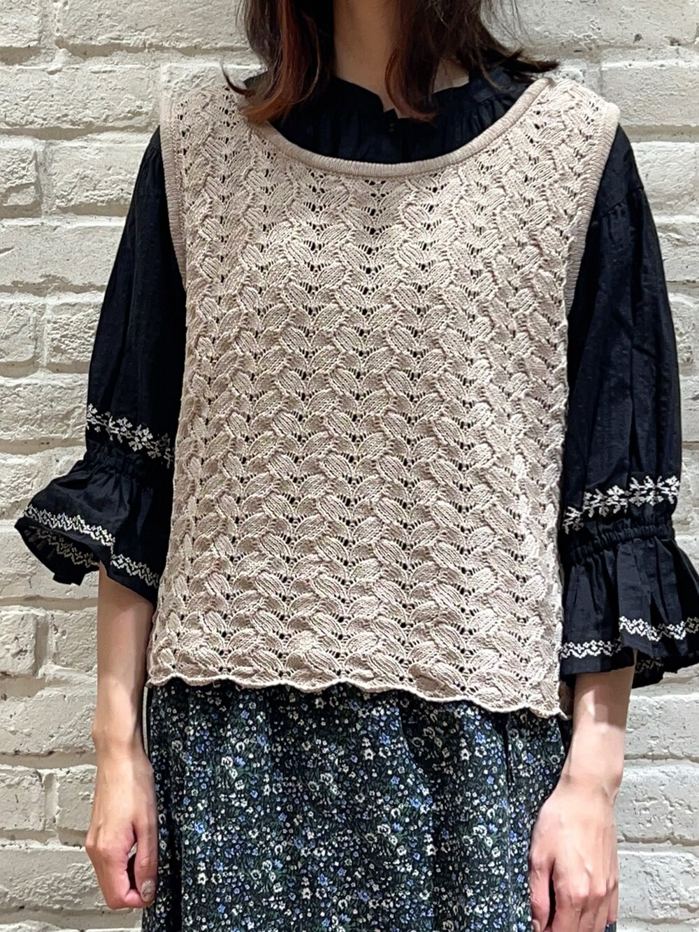 ベージュ系のベスト、ブラック系のシャツ/ブラウス、ブラック系のスカートを着用したレディースの秋コーディネートの2枚目の写真