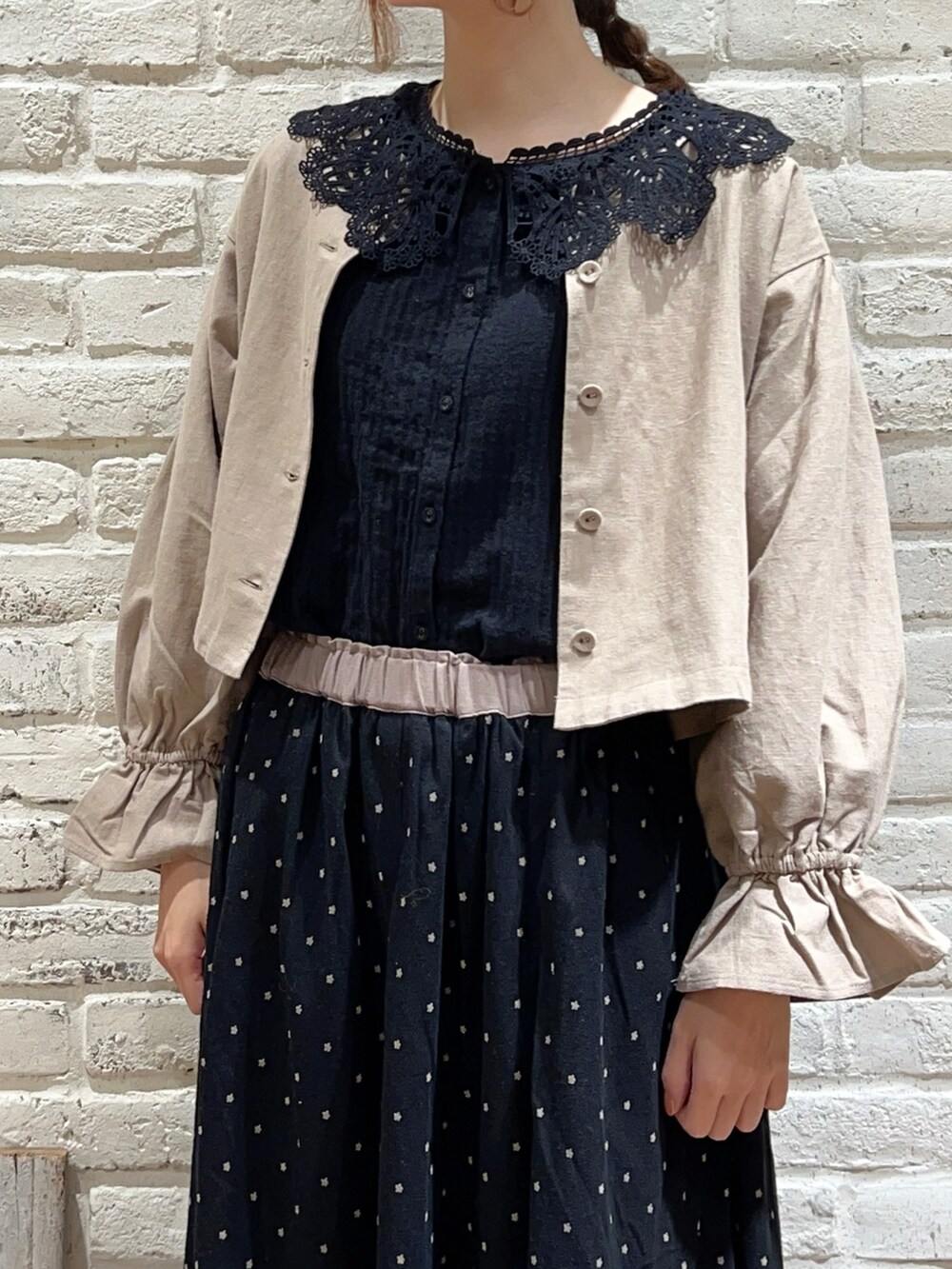 ブラック系のシャツ/ブラウス、ベージュ系のノーカラージャケット、ブラック系のスカートを着用したレディースの冬コーディネートの2枚目の写真