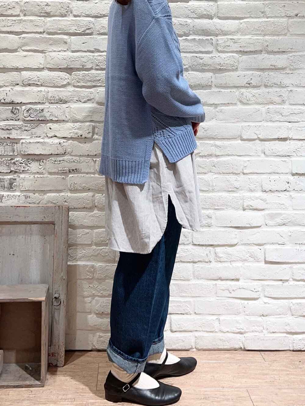 ブルー系のニット/セーター、ベージュ系のシャツ/ブラウス、ブルー系のデニムパンツを着用したレディースの冬コーディネートの3枚目の写真