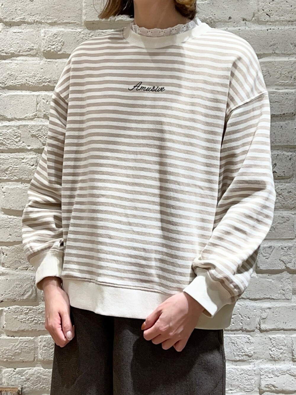 ホワイト系のTシャツ/カットソー、ホワイト系のニット/セーター、ベージュ系のワンピースを着用したレディースの冬コーディネートの2枚目の写真