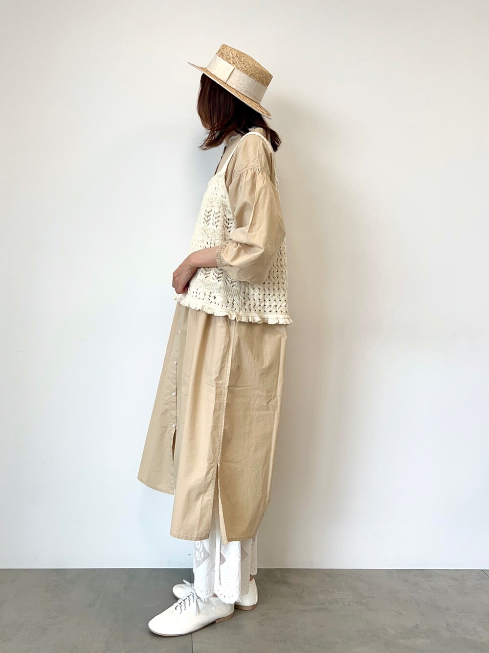 ホワイト系のベスト、ベージュ系のワンピース、ホワイト系のその他パンツを着用したレディースの春コーディネートの3枚目の写真