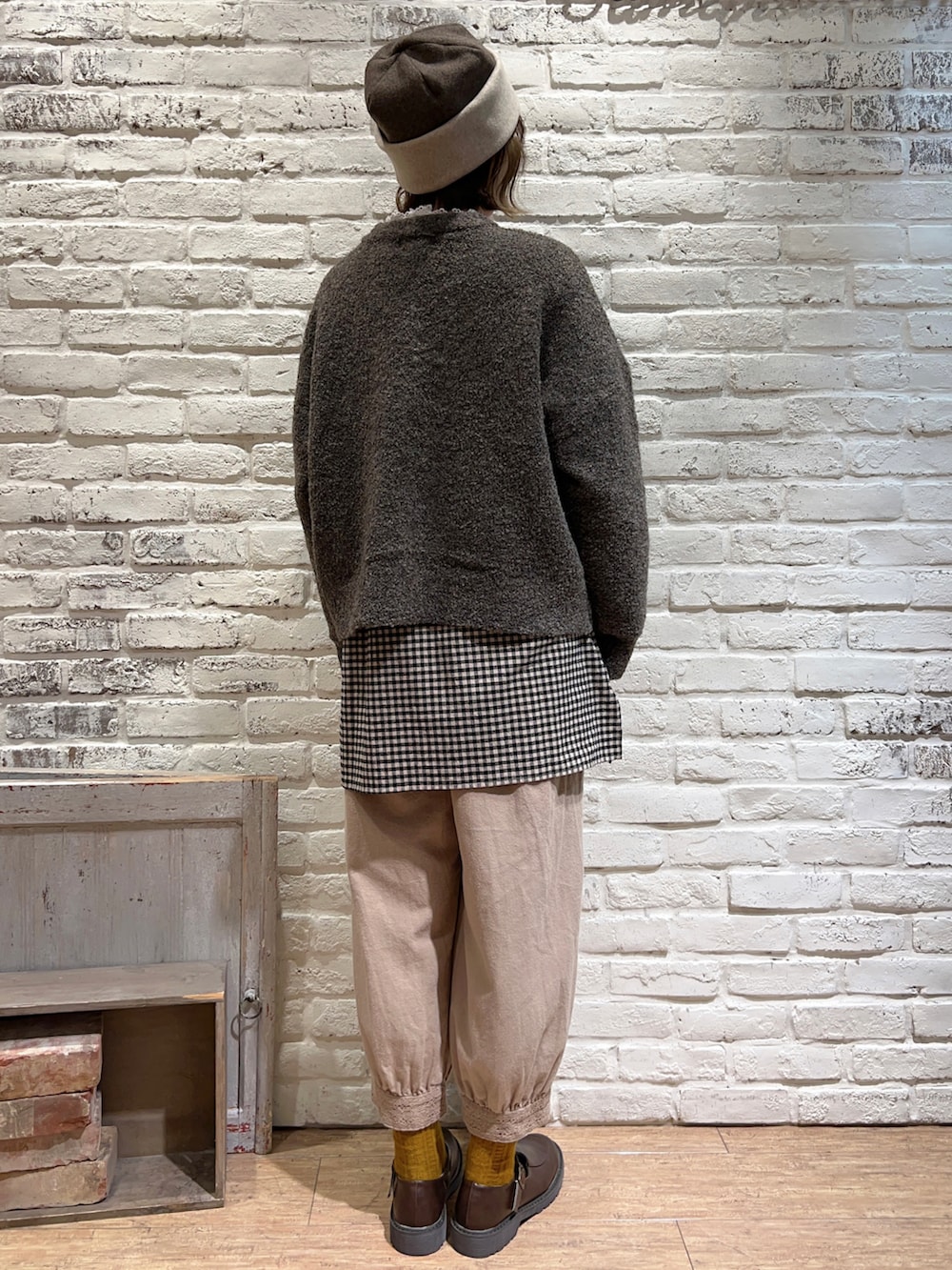 ホワイト系のTシャツ/カットソー、ブラウン系のカーディガン/ボレロ、ブラック系のチュニックを着用したレディースの秋コーディネートの4枚目の写真