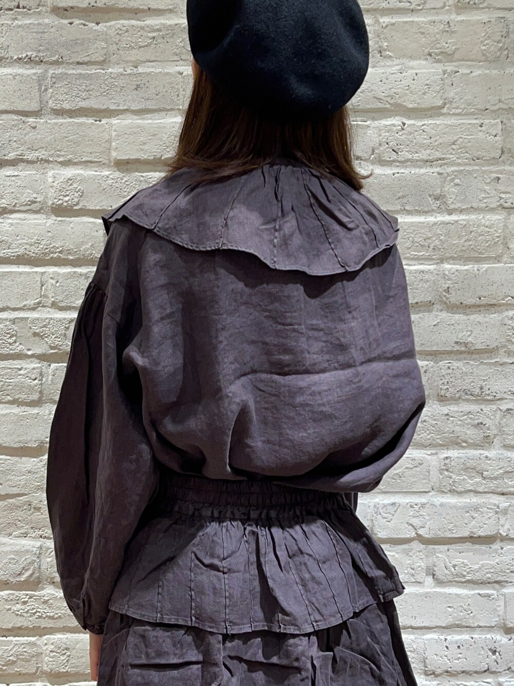 グレー系のシャツ/ブラウス、ブラック系のハンドバッグ、グレー系のスカートを着用したレディースの秋コーディネートの5枚目の写真