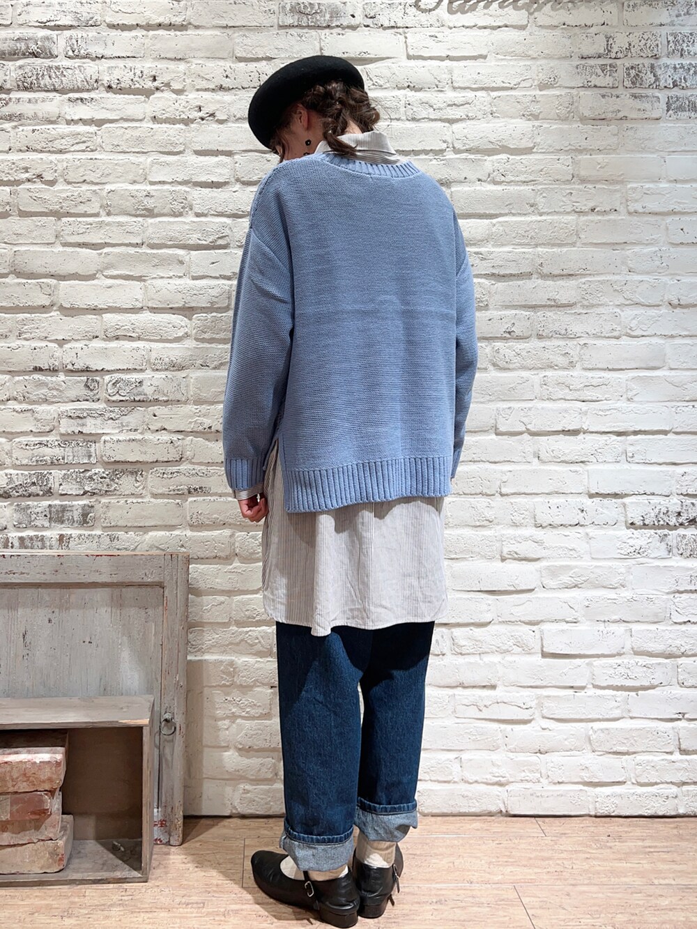 ブルー系のニット/セーター、ベージュ系のシャツ/ブラウス、ブルー系のデニムパンツを着用したレディースの冬コーディネートの4枚目の写真