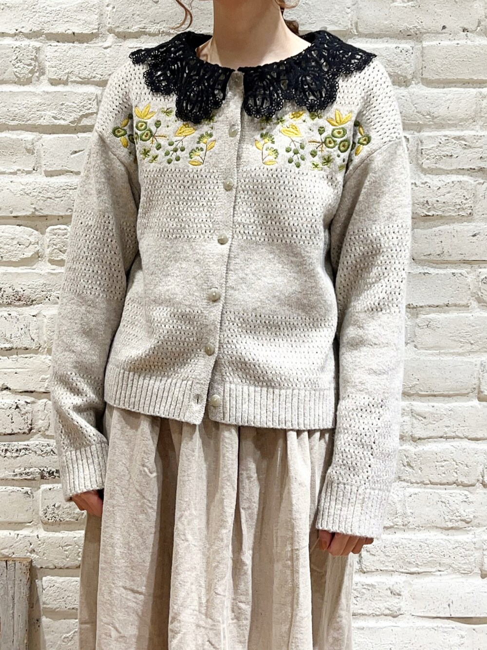 ブラック系のシャツ/ブラウス、ピンク系のカーディガン/ボレロ、ベージュ系のスカートを着用したレディースの冬コーディネートの2枚目の写真