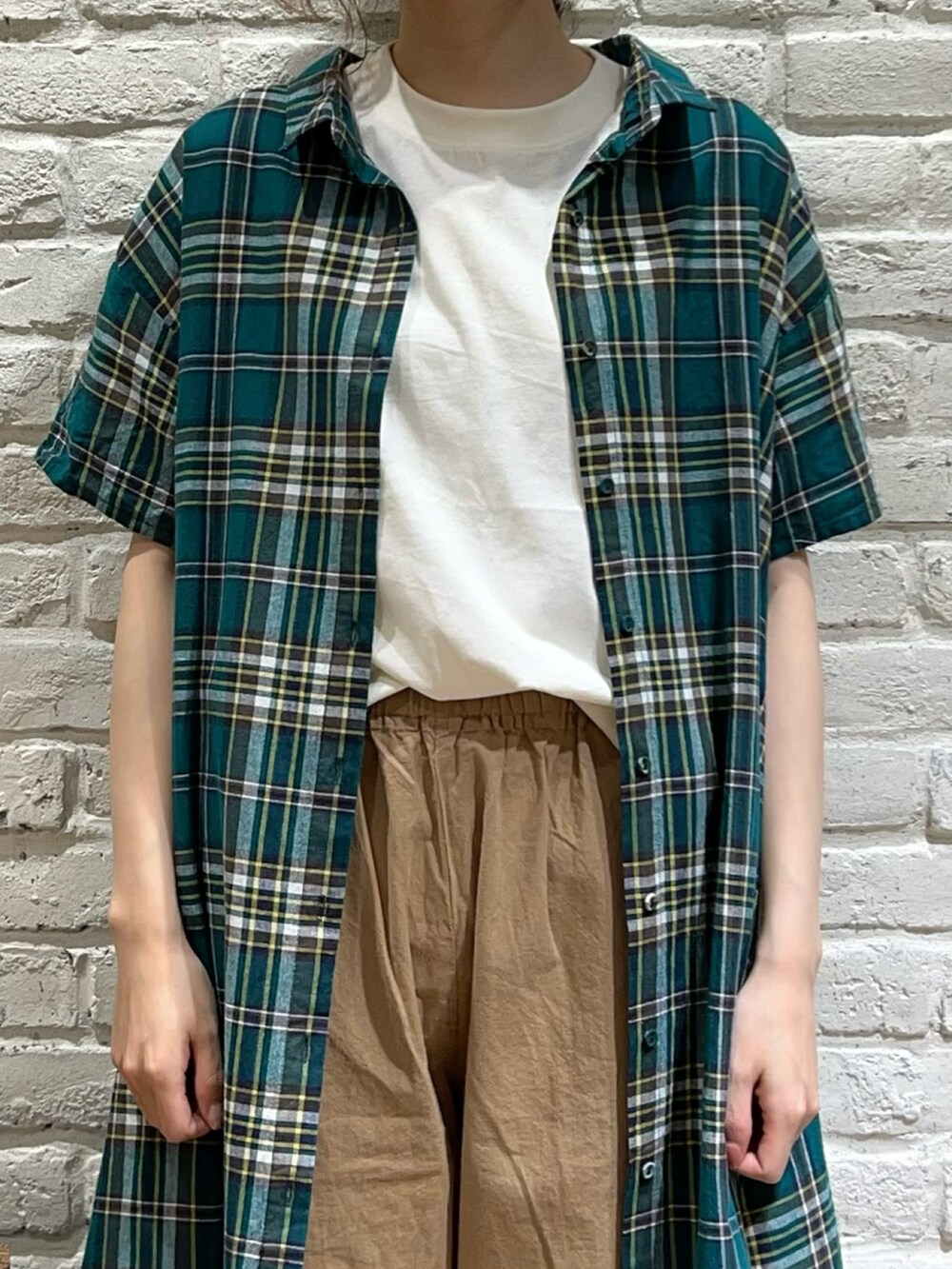 ホワイト系のTシャツ/カットソー、ホワイト系のキャミソール、グリーン系のシャツワンピースを着用したレディースの夏コーディネートの2枚目の写真