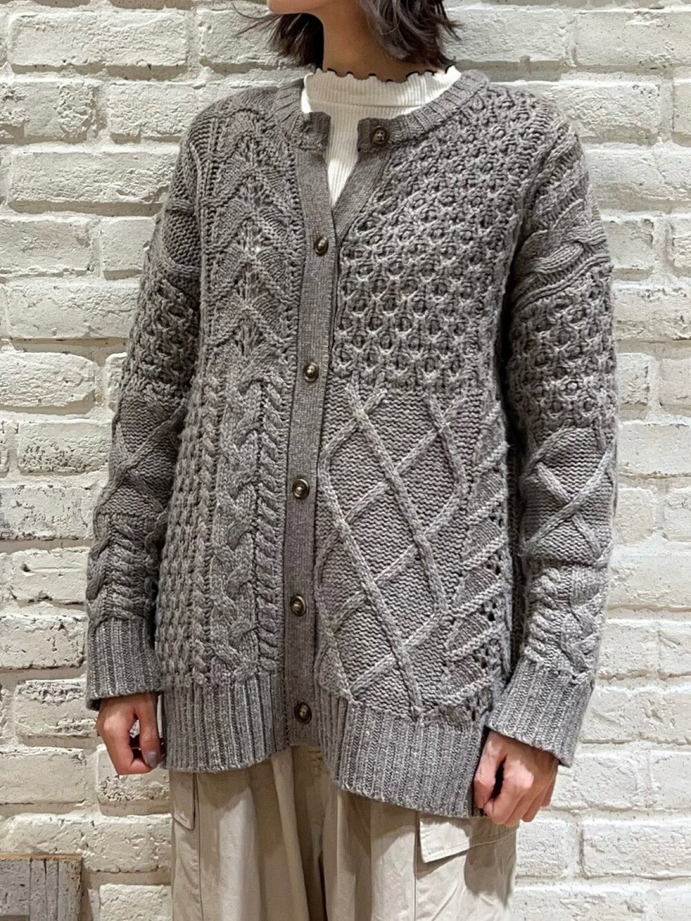 ホワイト系のTシャツ/カットソー、ブラウン系のカーディガン/ボレロ、ベージュ系のカーゴパンツを着用したレディースの冬コーディネートの2枚目の写真