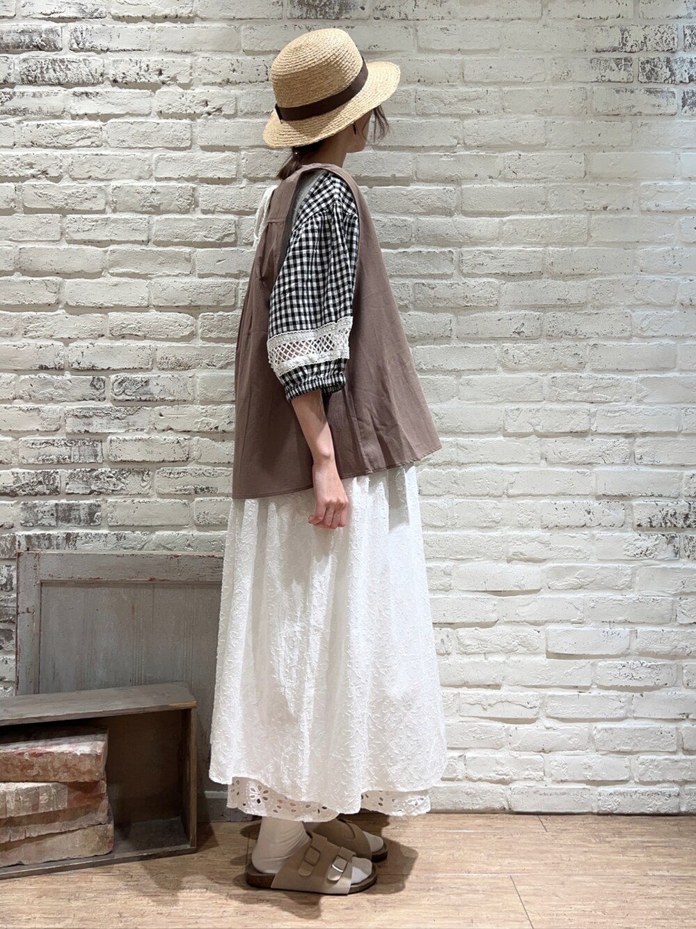ブラウン系のベスト、ブラック系のシャツ/ブラウス、ホワイト系のワンピースを着用したレディースの夏コーディネートの3枚目の写真