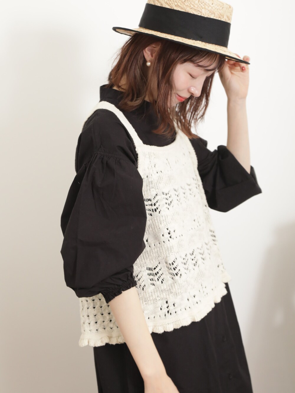 ホワイト系のベスト、ブラック系のワンピース、ブルー系のその他パンツを着用したレディースの春コーディネートの2枚目の写真