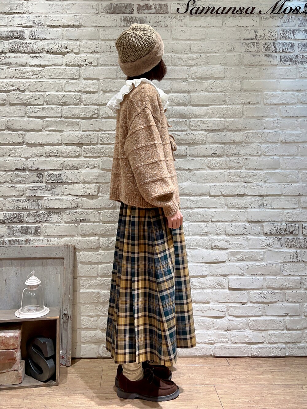 ホワイト系のシャツ/ブラウス、オレンジ系のカーディガン/ボレロ、グリーン系のスカートを着用したレディースの冬コーディネートの4枚目の写真