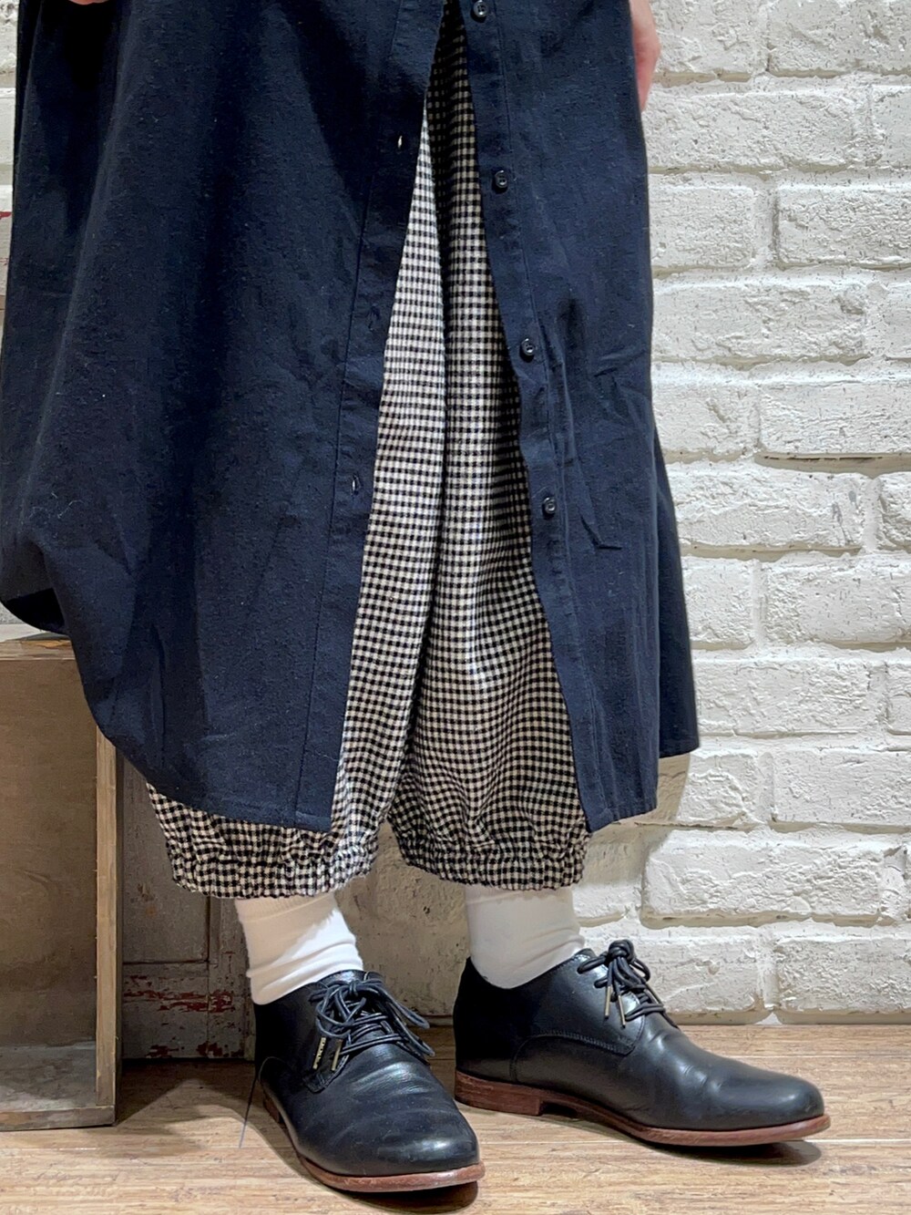 ホワイト系のTシャツ/カットソー、ブラウン系のベスト、ブラック系のワンピースを着用したレディースの冬コーディネートの5枚目の写真