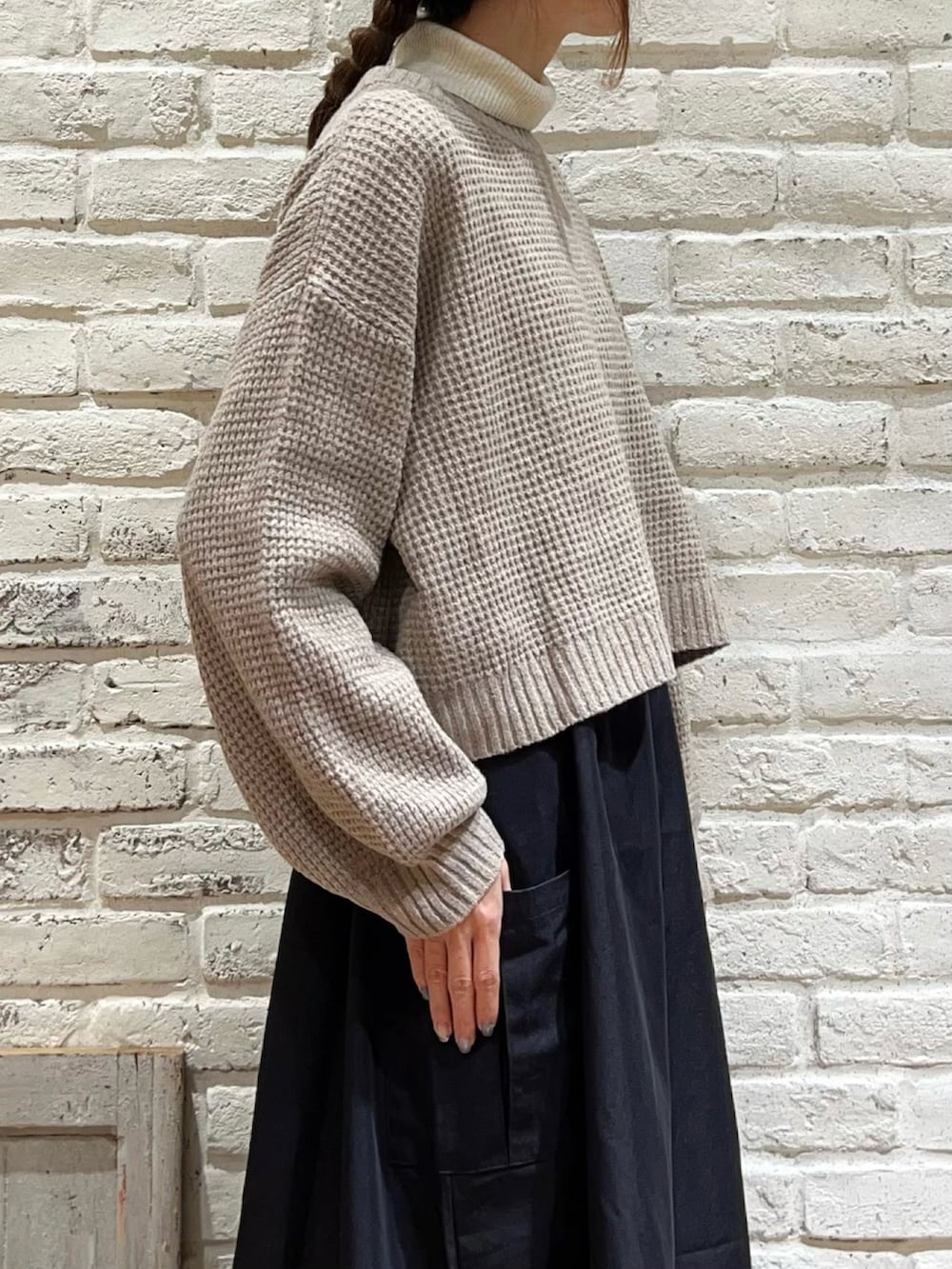 ホワイト系のニット/セーター、ブラック系のハンドバッグ、ブラック系のワンピースを着用したレディースの冬コーディネートの3枚目の写真