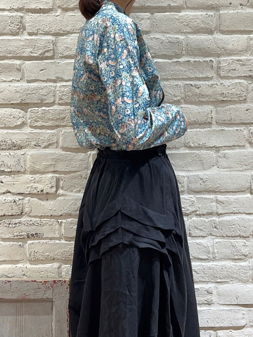 グリーン系のシャツ/ブラウス、ブラック系のスカート、ブラック系のサンダルを着用したレディースの春コーディネートの3枚目の写真