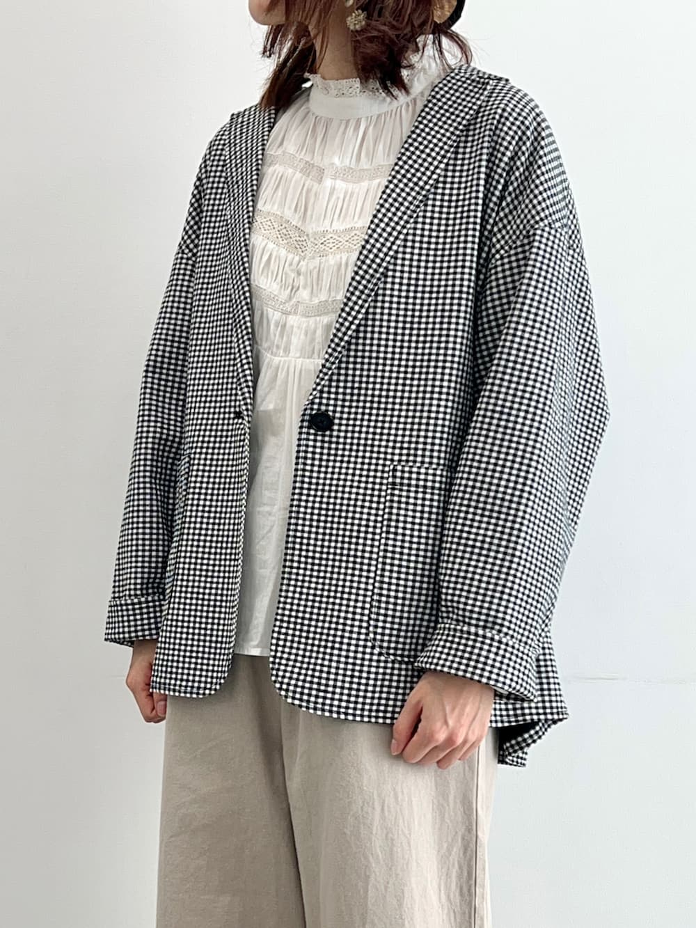 ブラック系のノーカラージャケット、ホワイト系のシャツ/ブラウス、ベージュ系のその他パンツを着用したレディースの春コーディネートの2枚目の写真