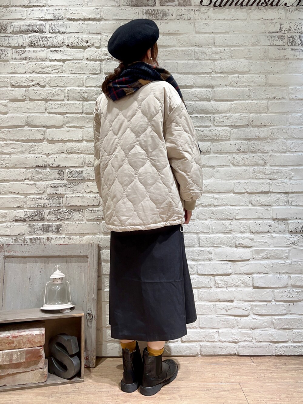 ベージュ系のブルゾン、ブラック系のワンピース、ブラック系のブーツを着用したレディースの冬コーディネートの5枚目の写真