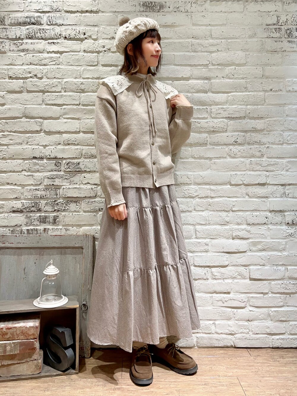 ホワイト系のシャツ/ブラウス、ベージュ系のニット/セーター、ベージュ系のスカートを着用したレディースの冬コーディネートの3枚目の写真