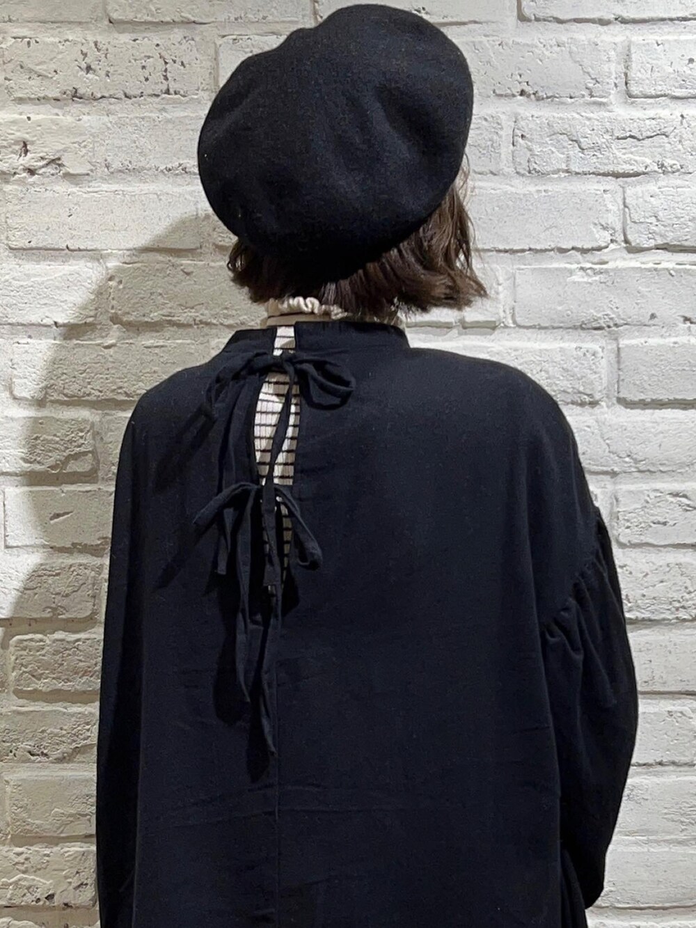 ホワイト系のニット/セーター、ブラック系のワンピース、ベージュ系のその他パンツを着用したレディースの冬コーディネートの5枚目の写真