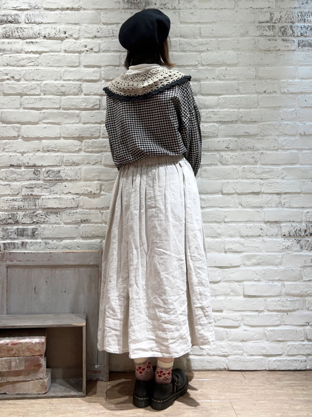 ホワイト系のニット/セーター、ブラック系のチュニック、ホワイト系のスカートを着用したレディースの冬コーディネートの4枚目の写真