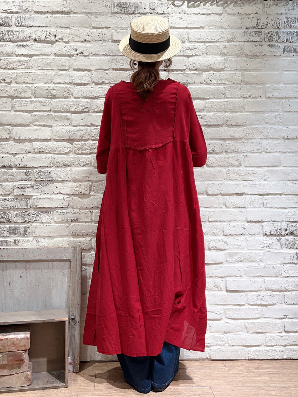 ホワイト系のTシャツ/カットソー、レッド系のワンピース、ブルー系のデニムパンツを着用したレディースの春コーディネートの4枚目の写真