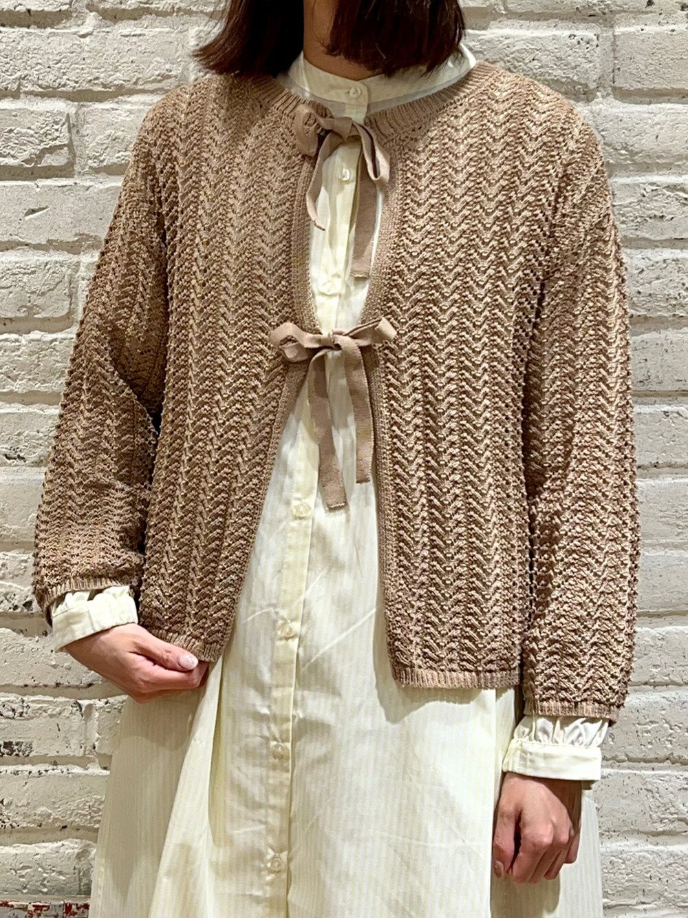 ベージュ系のカーディガン/ボレロ、ホワイト系のハンドバッグ、イエロー系のシャツワンピースを着用したレディースの春コーディネートの2枚目の写真