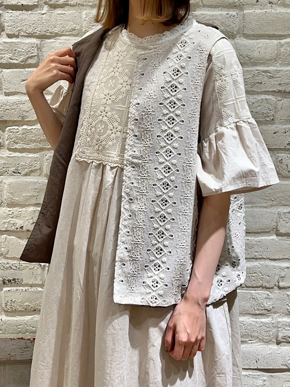 ホワイト系のタンクトップ、ホワイト系のベスト、ホワイト系のワンピースを着用したレディースの春コーディネートの3枚目の写真