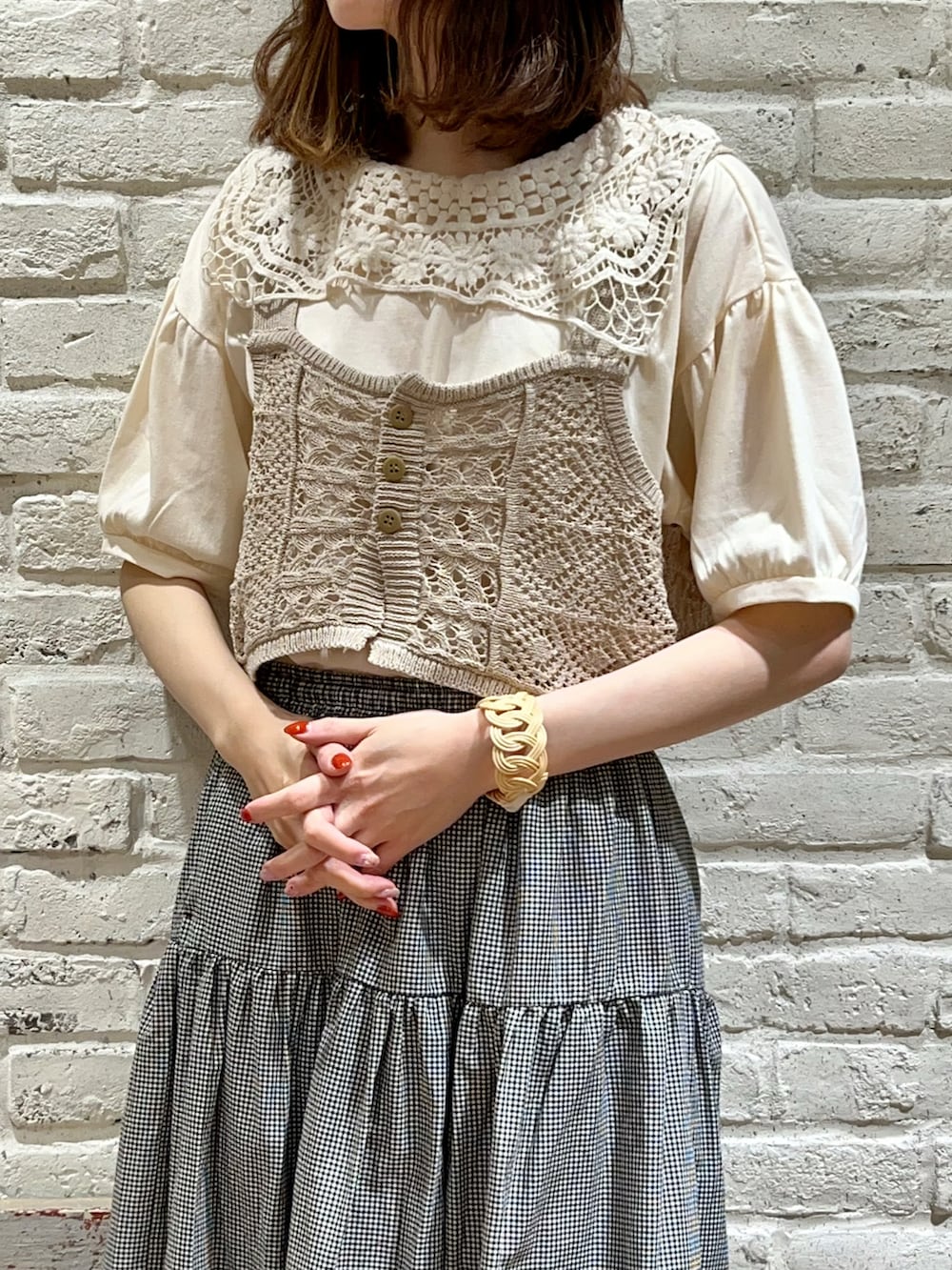 ホワイト系のTシャツ/カットソー、ベージュ系のベスト、ベージュ系のハンドバッグを着用したレディースの秋コーディネートの2枚目の写真