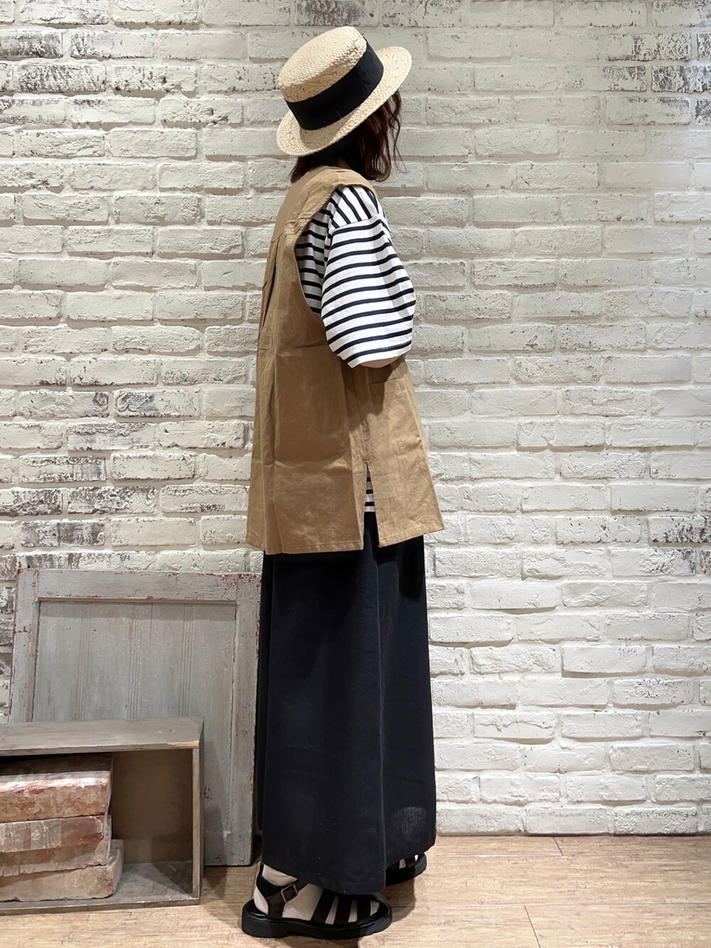 ホワイト系のTシャツ/カットソー、ベージュ系のベスト、ブラック系のハンドバッグを着用したレディースの春コーディネートの3枚目の写真